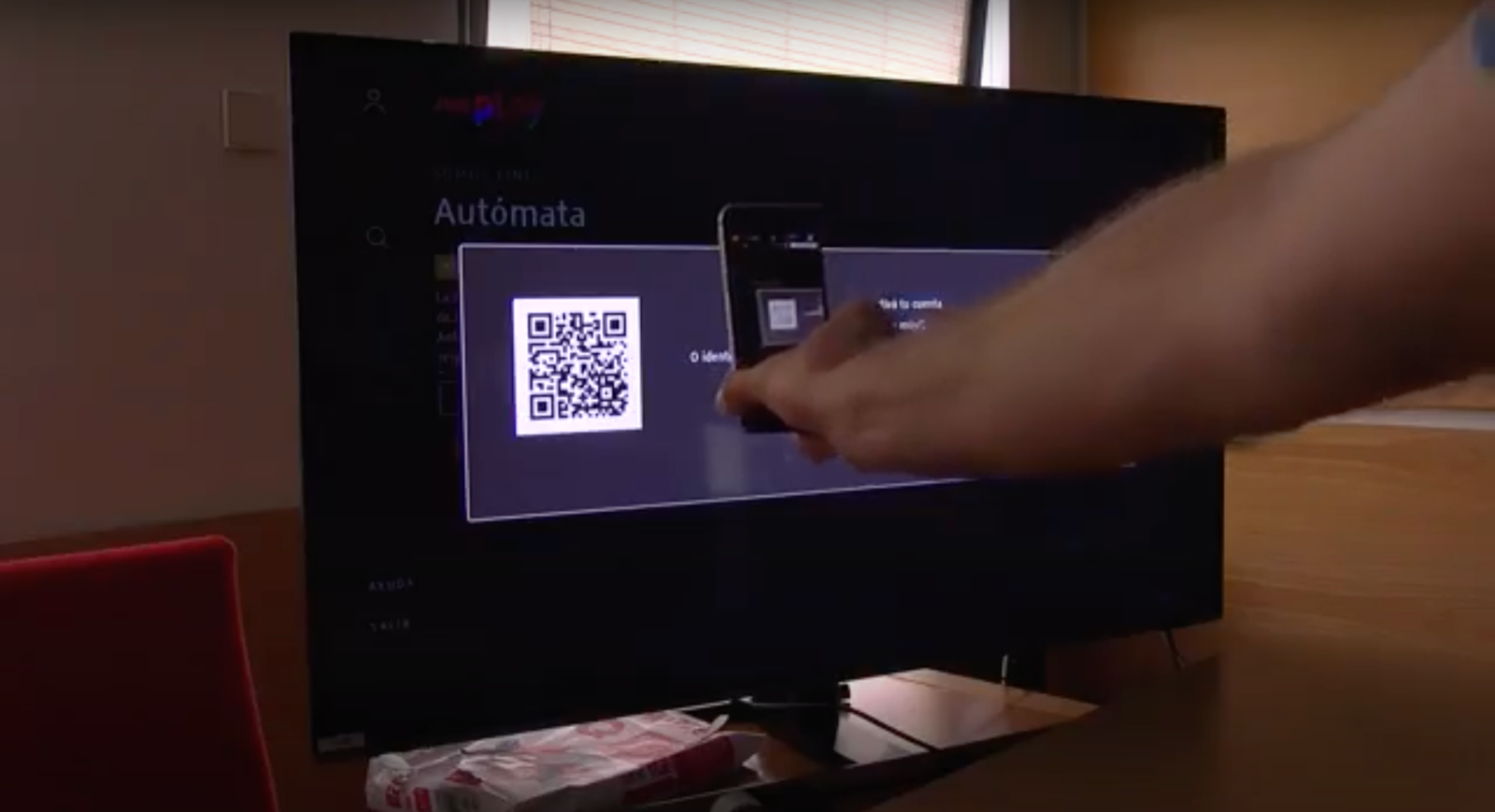 Una persona escanea con el móvil un código QR mostrado en un televisor durante una prueba de RTVE.