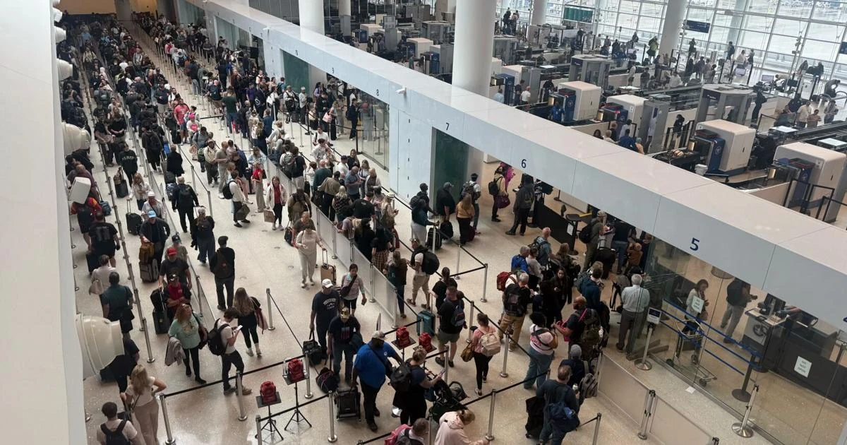 Personas esperando en las filas de control de un aeropuerto.